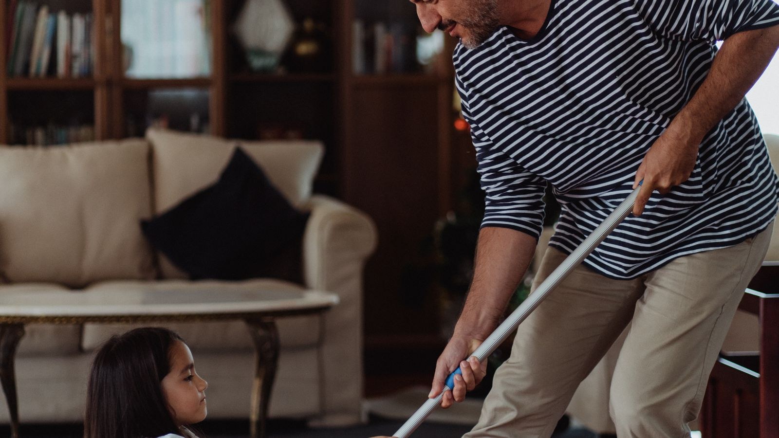 Mopping wooden floor boards along the grain with a microfiber pad
