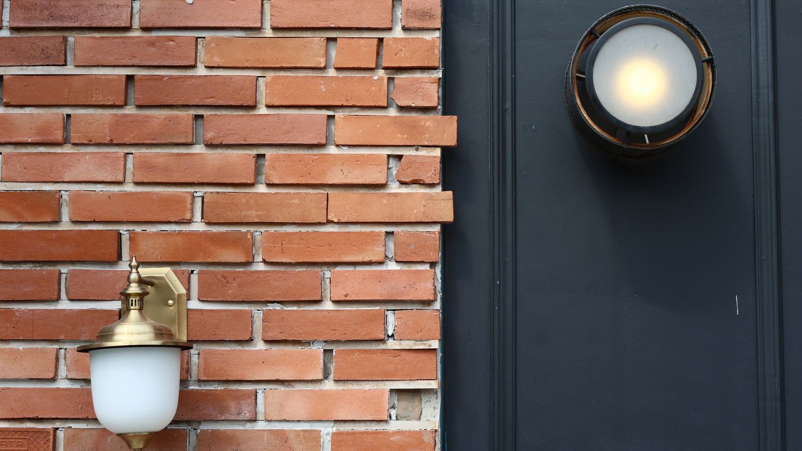 Modern outdoor wall light fixtures mounted on an exterior brick wall