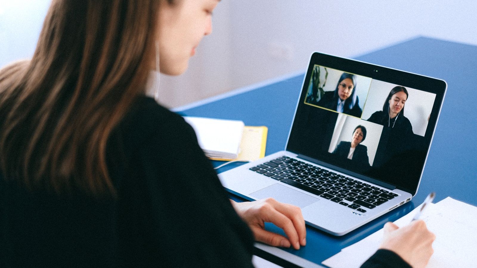 Home office desk with webcam and lamp arranged for better video call quality