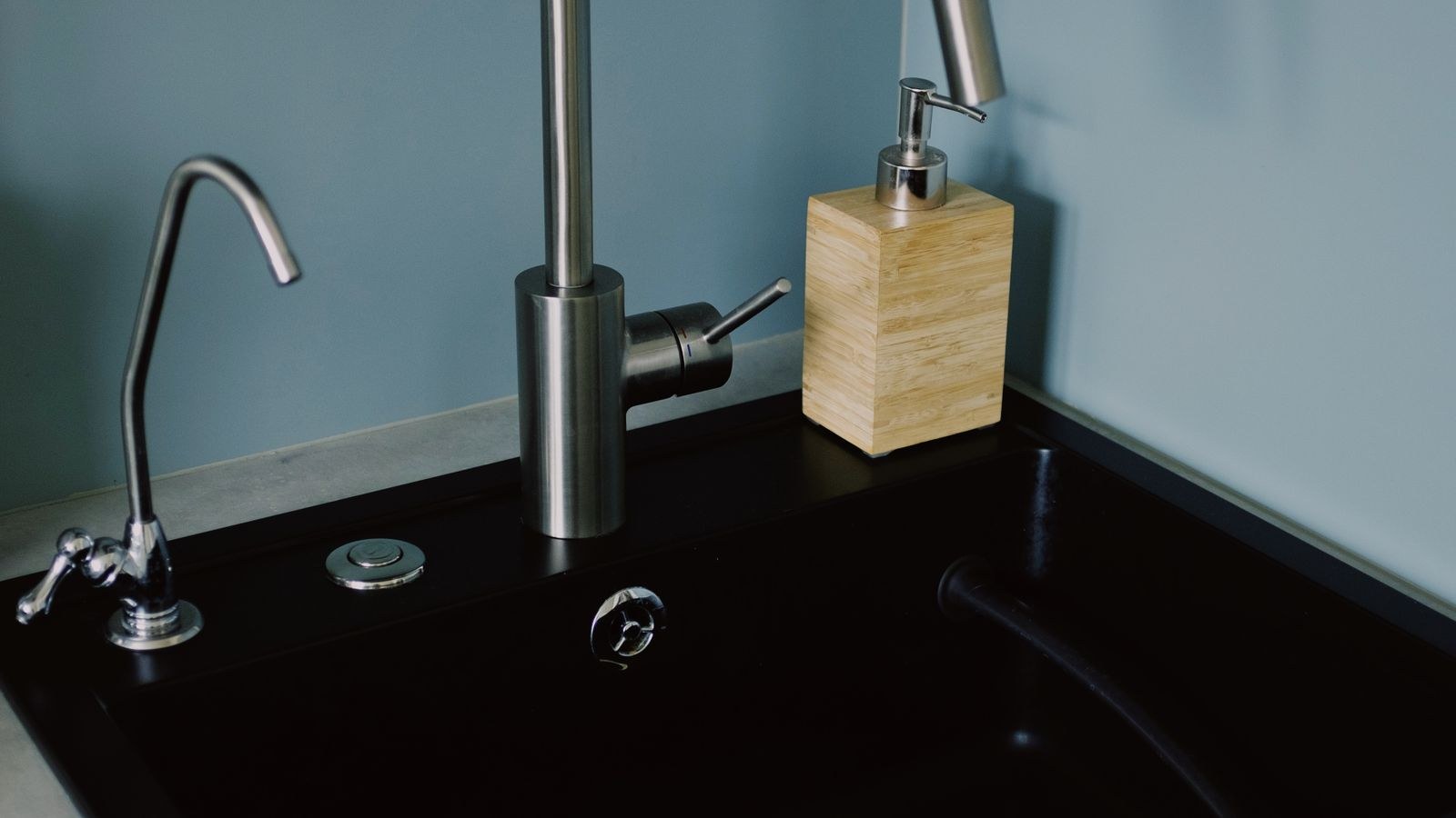 Bathroom vanity plumbing with shutoff valves near a leak detection sensor