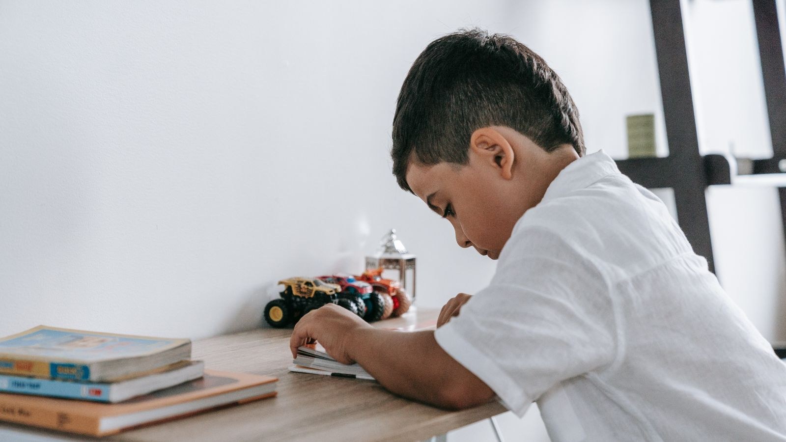 Child reading at a low child-sized desk in a bright room