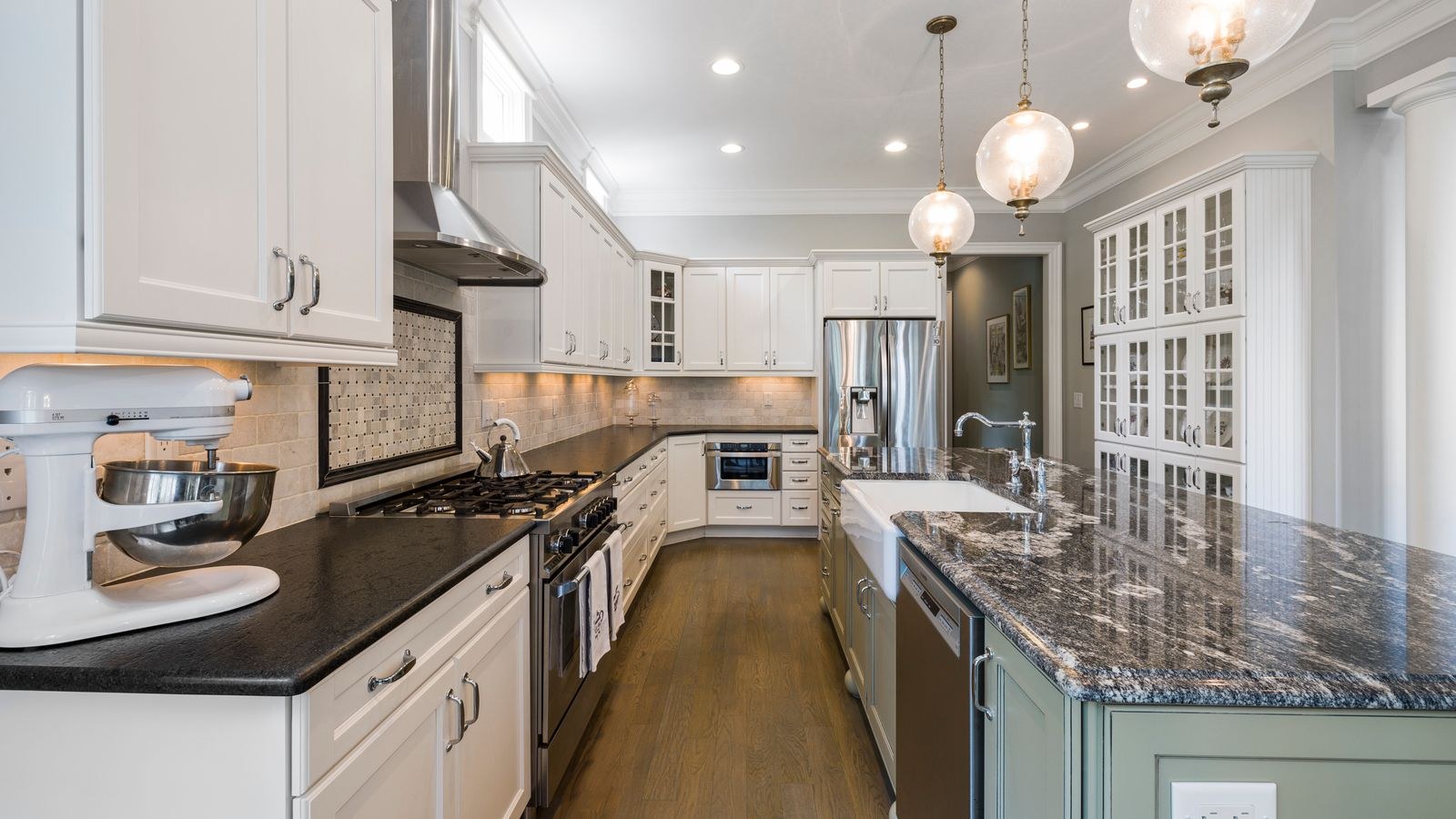 Spacious contemporary kitchen featuring a marble island and pendant lighting