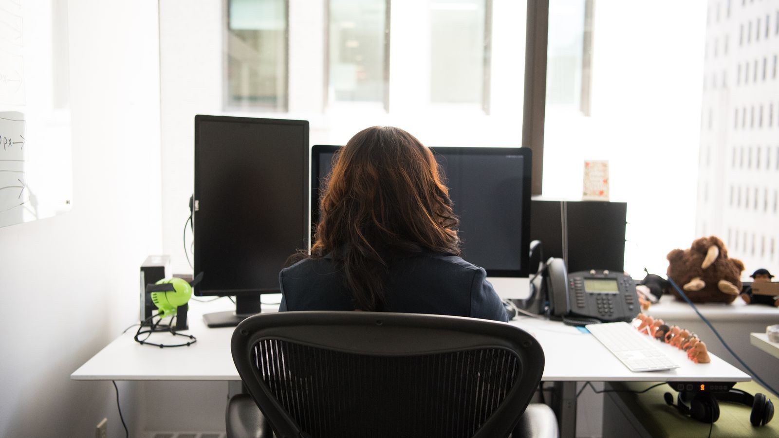 Person sitting upright at a desk with an open hip angle posture