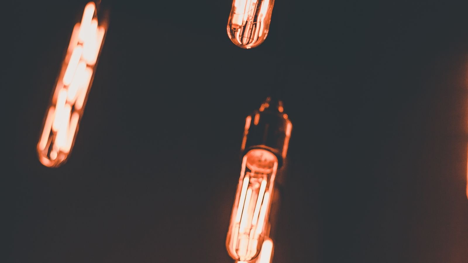 Dimmable LED filament bulbs glowing warmly against a dark background