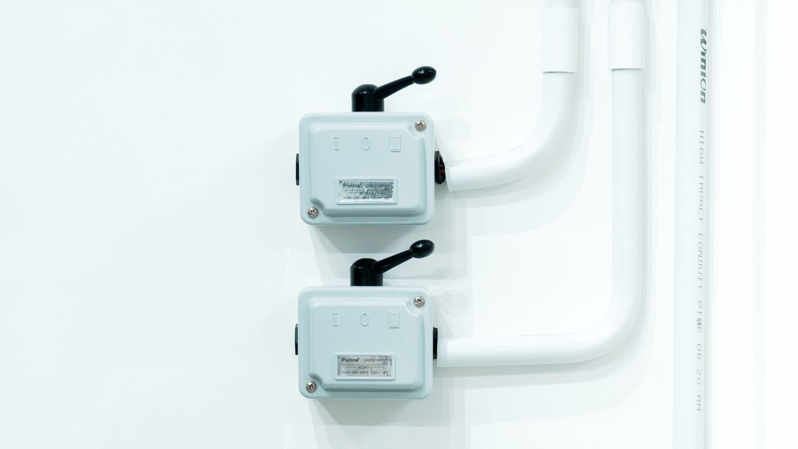 Modern white electrical dimmer and light switches mounted on a wall