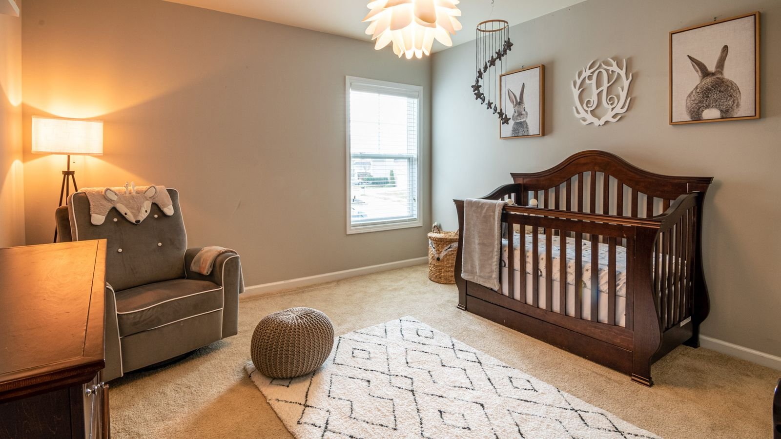Child's bedroom lit with soft warm lamp lighting near a crib