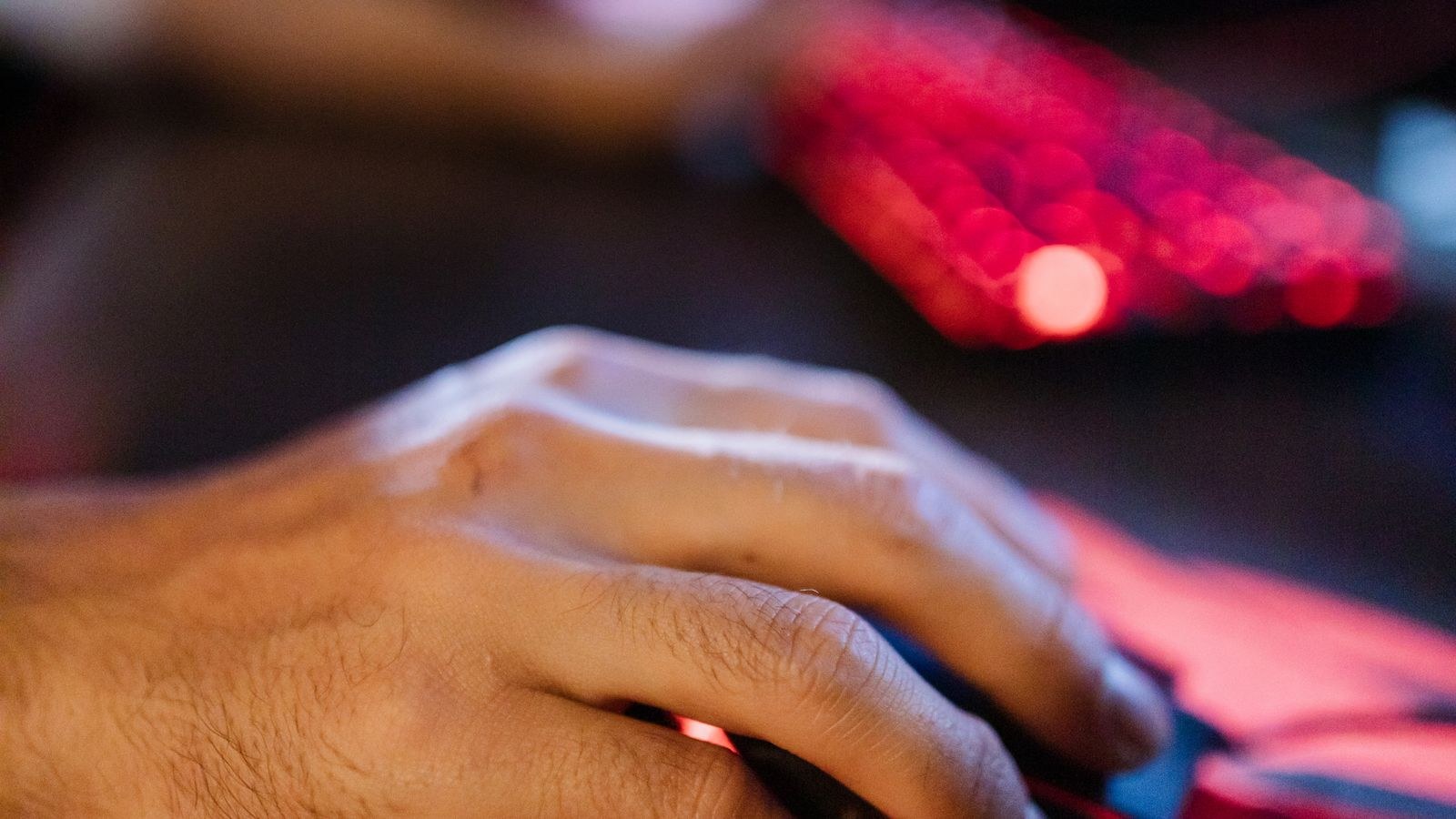 Focused hand using a gaming mouse on a large mouse pad