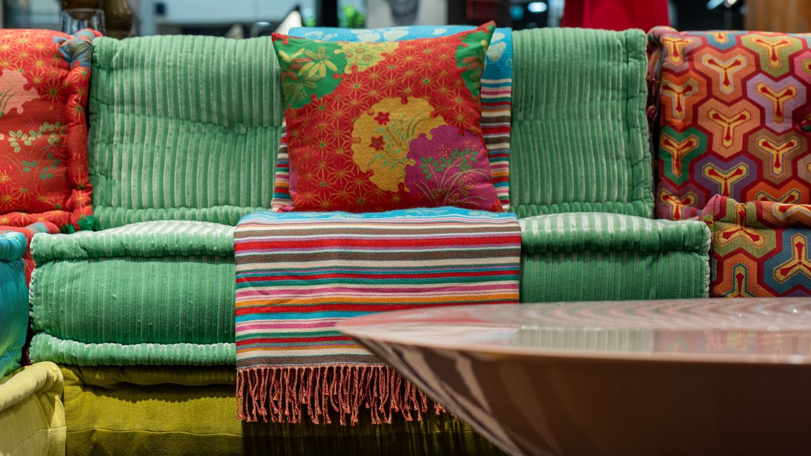 Colorful velvet sofa and round table in a styled living room palette