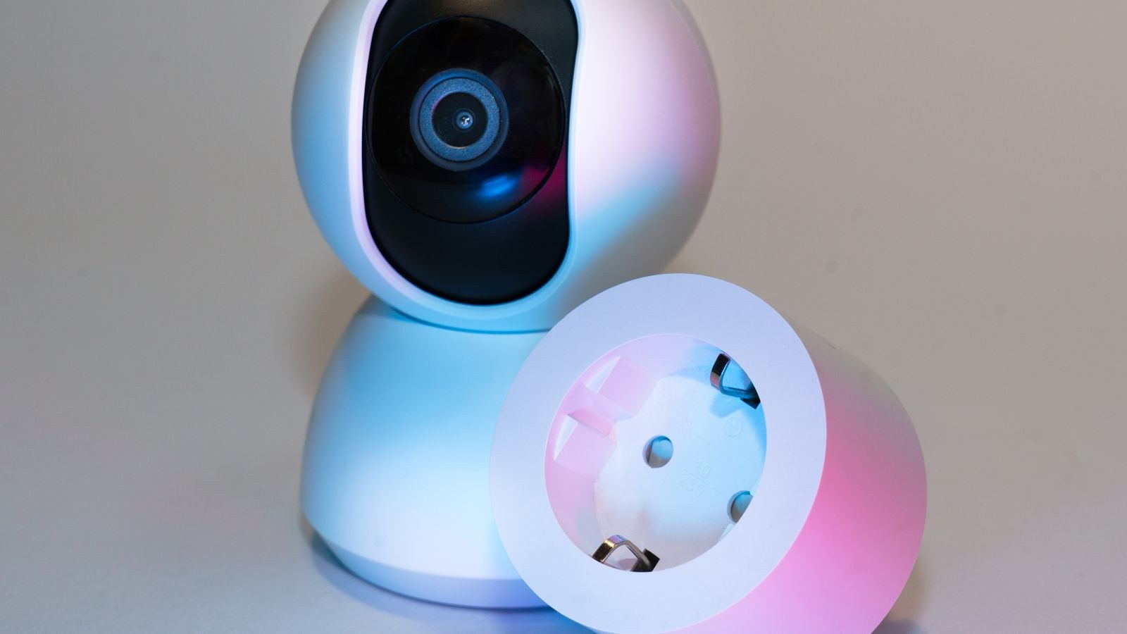 Smart home security camera and smart plug on a neutral background