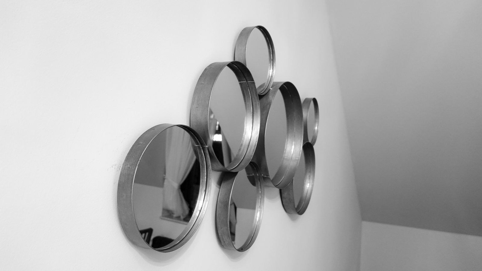 Round decorative mirrors arranged on a white wall