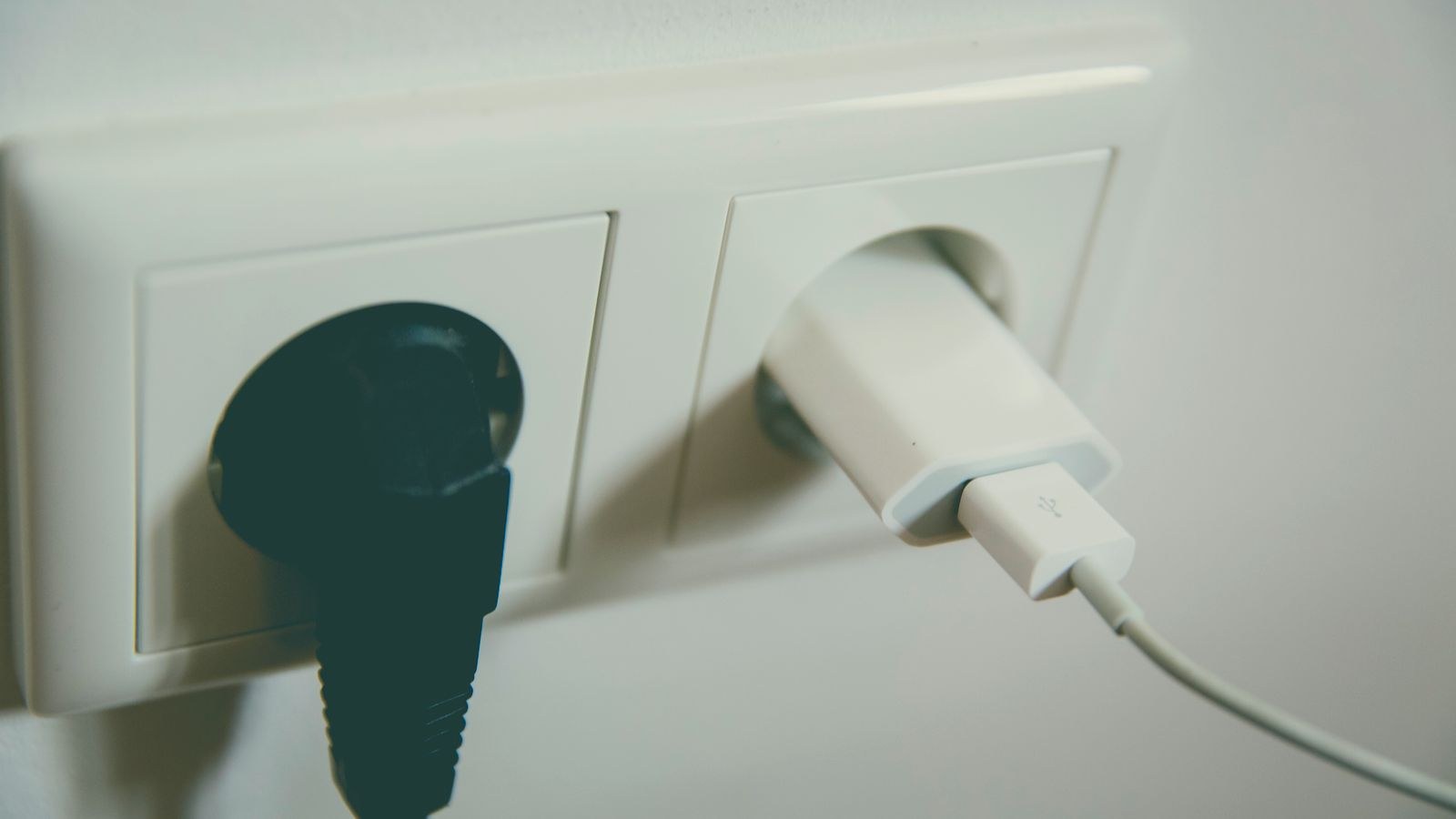 Wall power outlet with plugs connected, showing grounded electrical protection