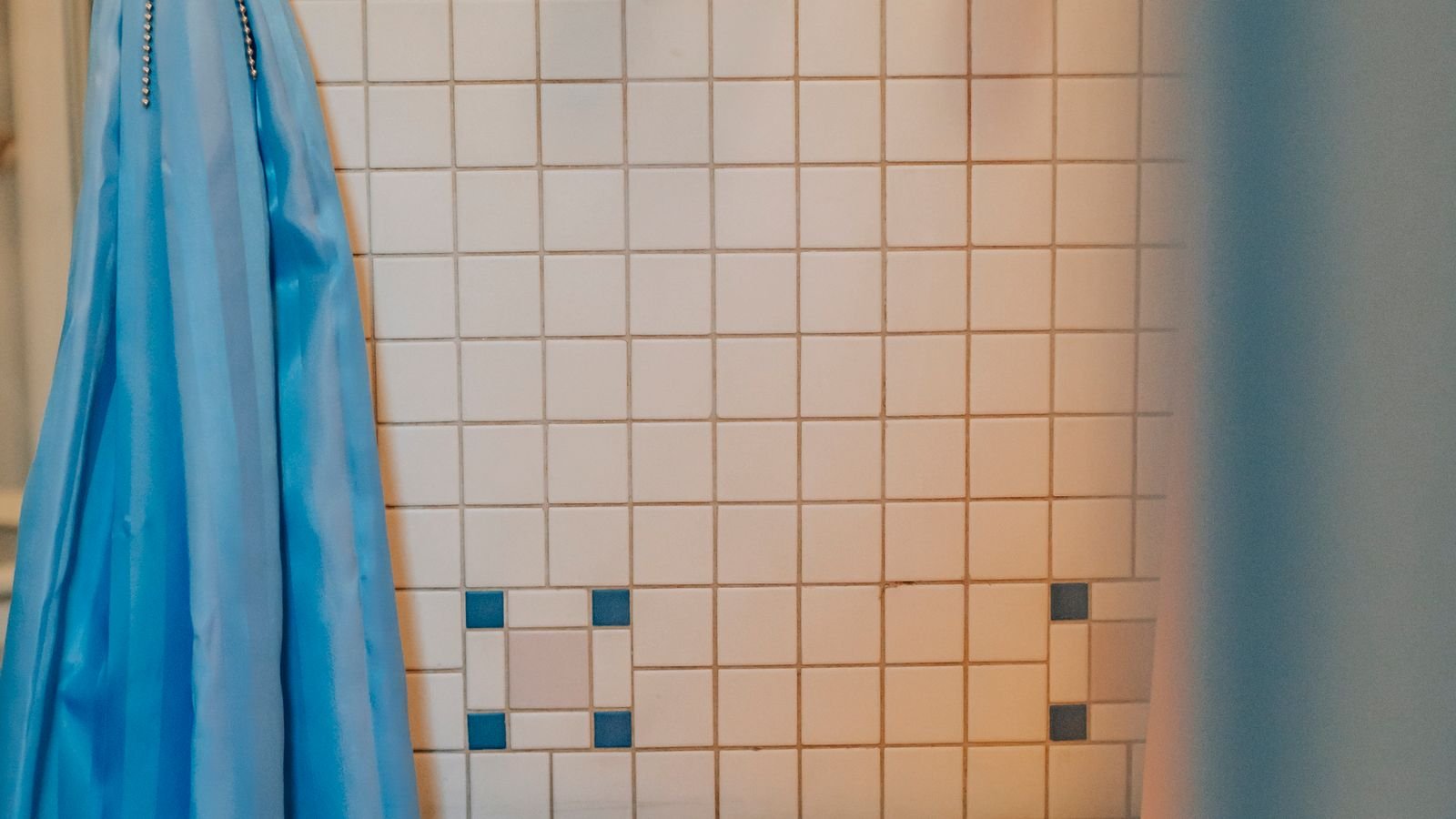 Fabric shower curtain hanging in a bright modern bathroom