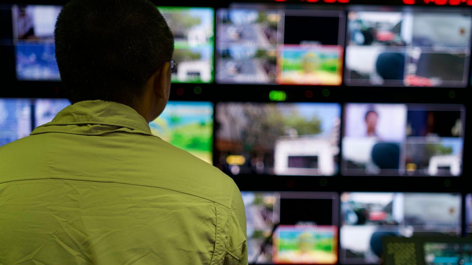 Operator monitoring multiple CCTV screens in a security control room