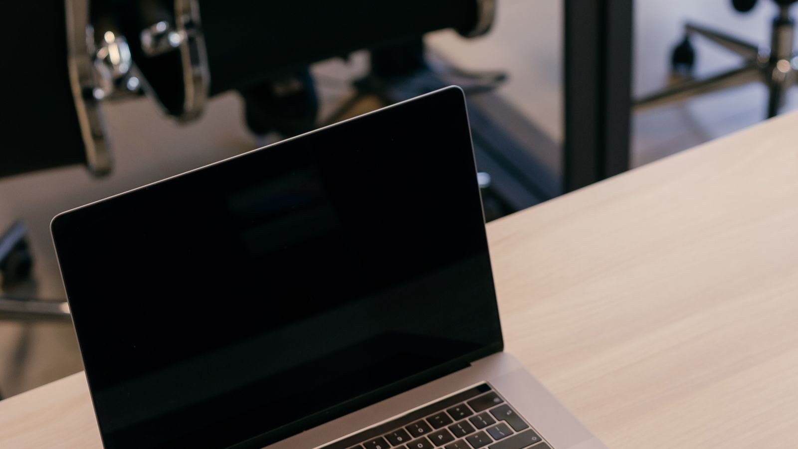 Modern black task chairs beside a desk with a laptop
