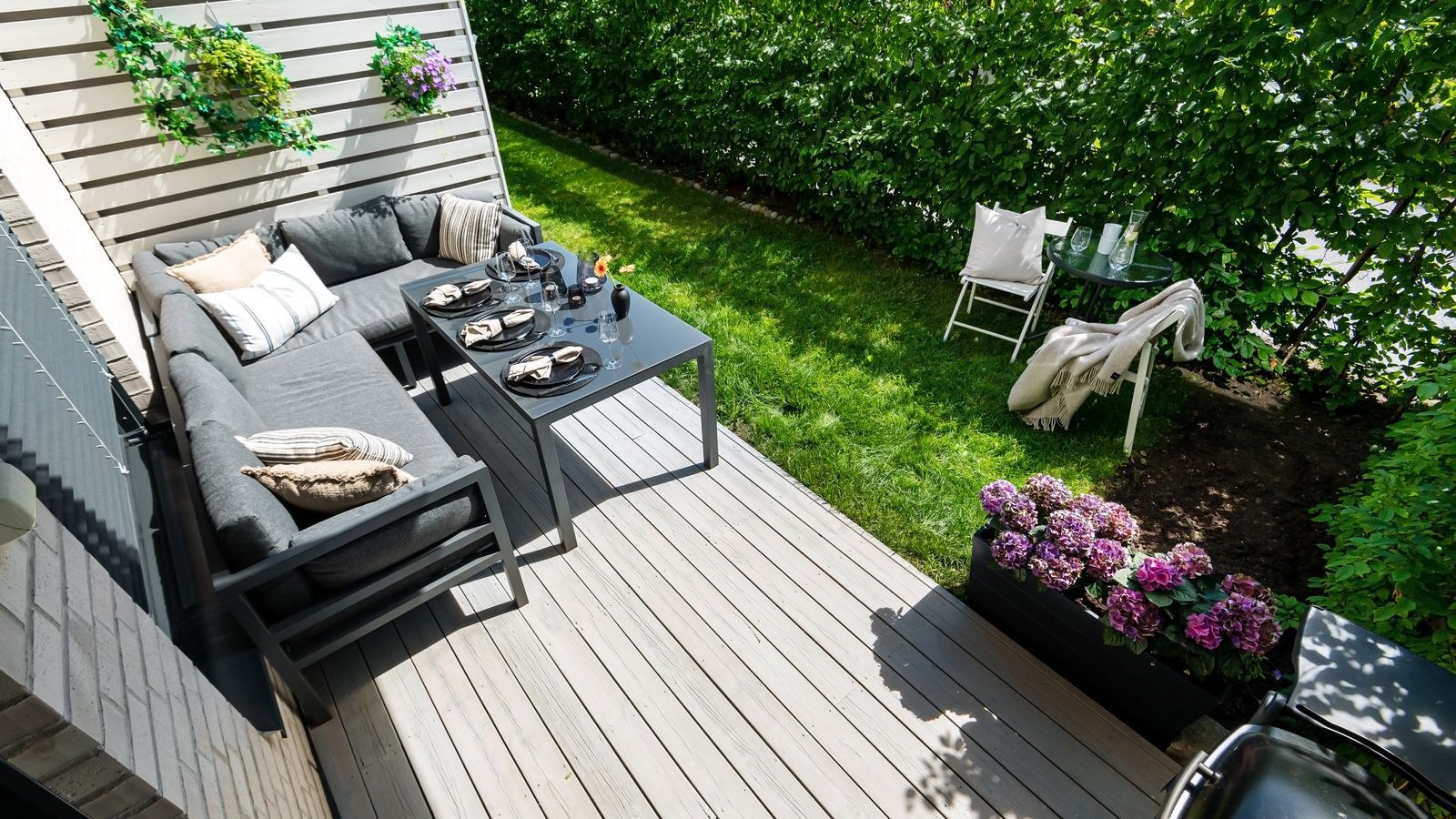 Stylish outdoor patio area with seating and a grill under cover