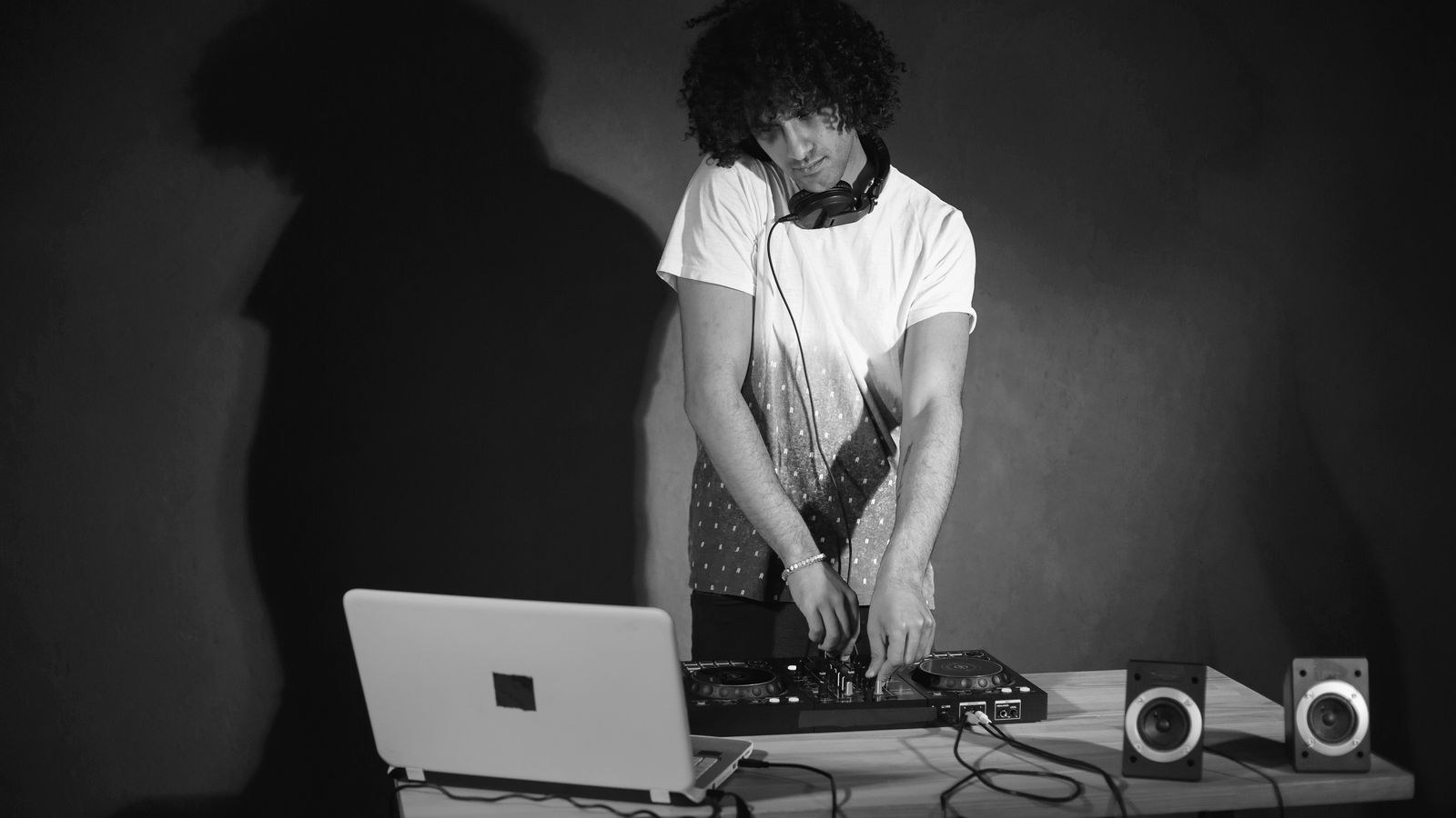 DJ mixing music with speakers at a house party