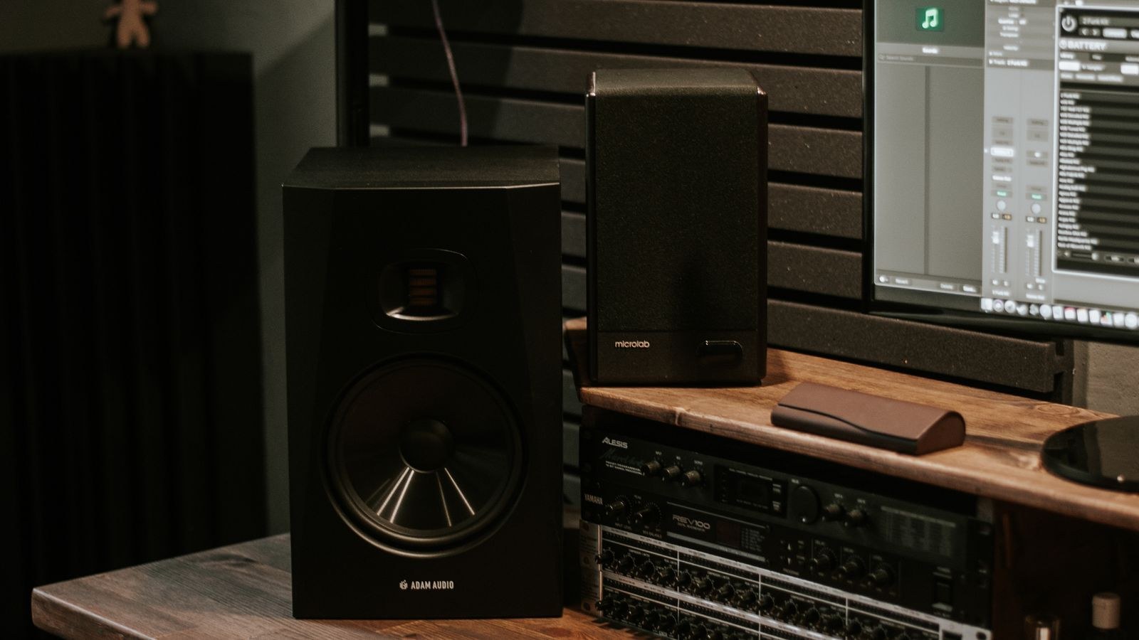 Studio speakers computer and headphones arranged on a wooden desk
