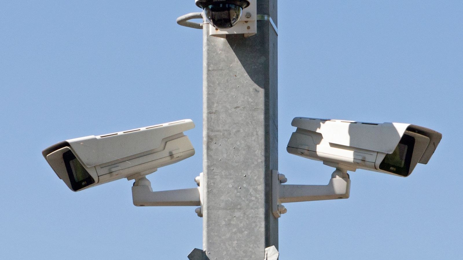 Outdoor surveillance system with multiple wired security cameras on a metal pole