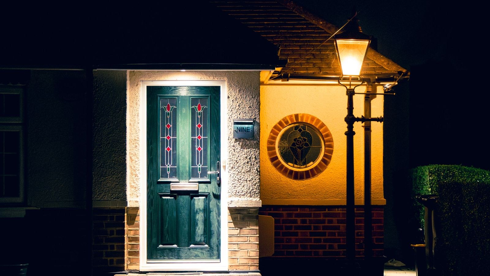 Suburban front entry illuminated by warm porch lighting at night