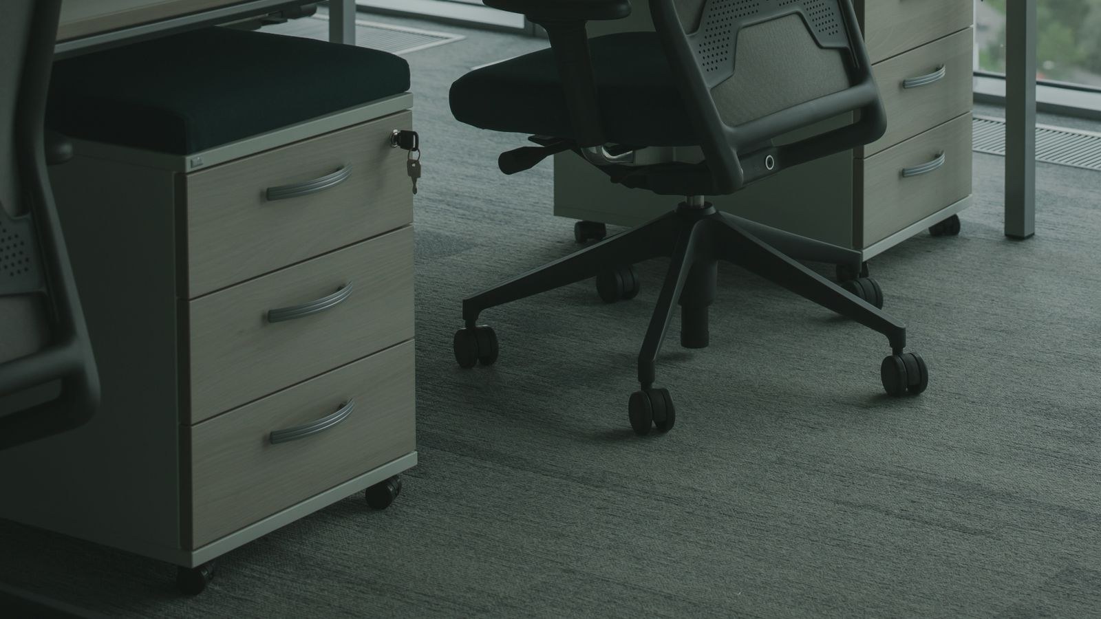 Office chair on carpet in a home office showing wear under the wheels