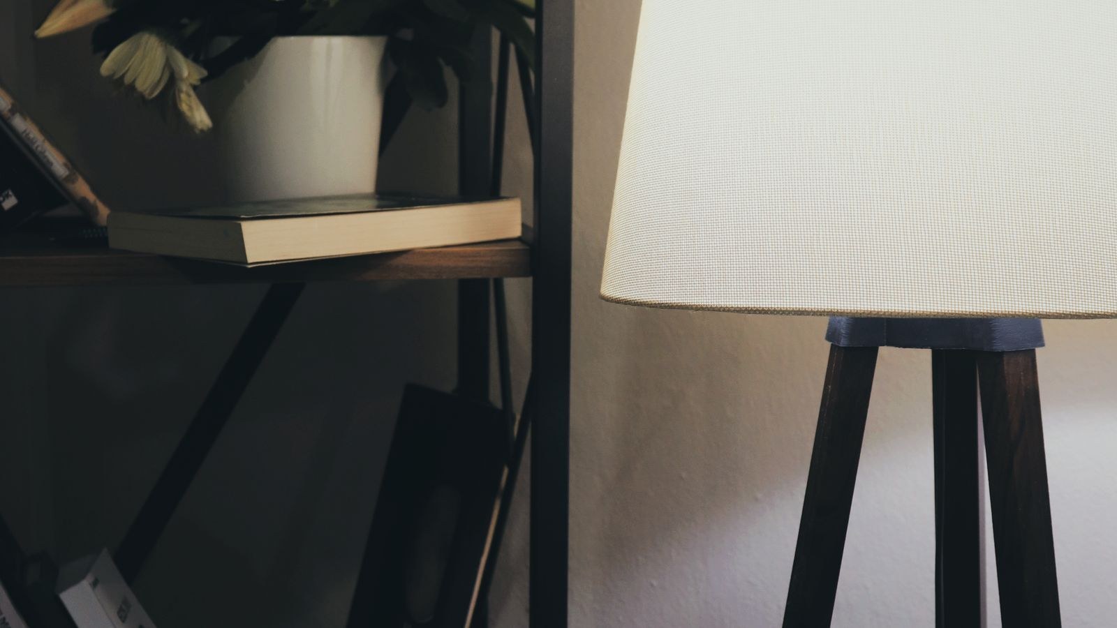 Adjustable arm desk lamp positioned over books and reading material
