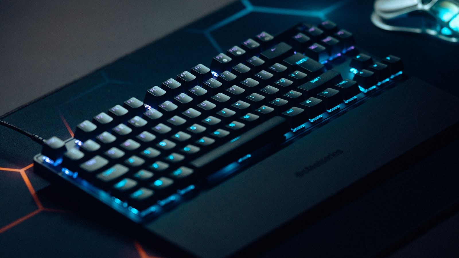 RGB backlit mechanical gaming keyboard on a dark desk setup