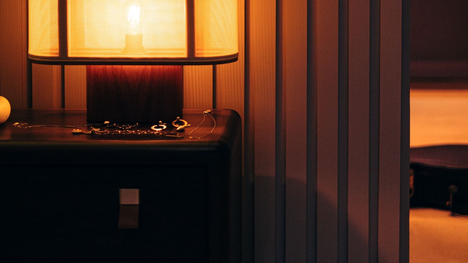 Dim warm bedside lighting in a dark bedroom at night
