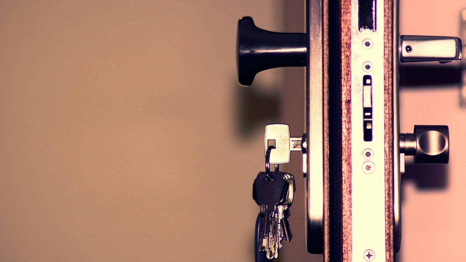 Deadbolt lock cylinder and house keys laid out for rekeying