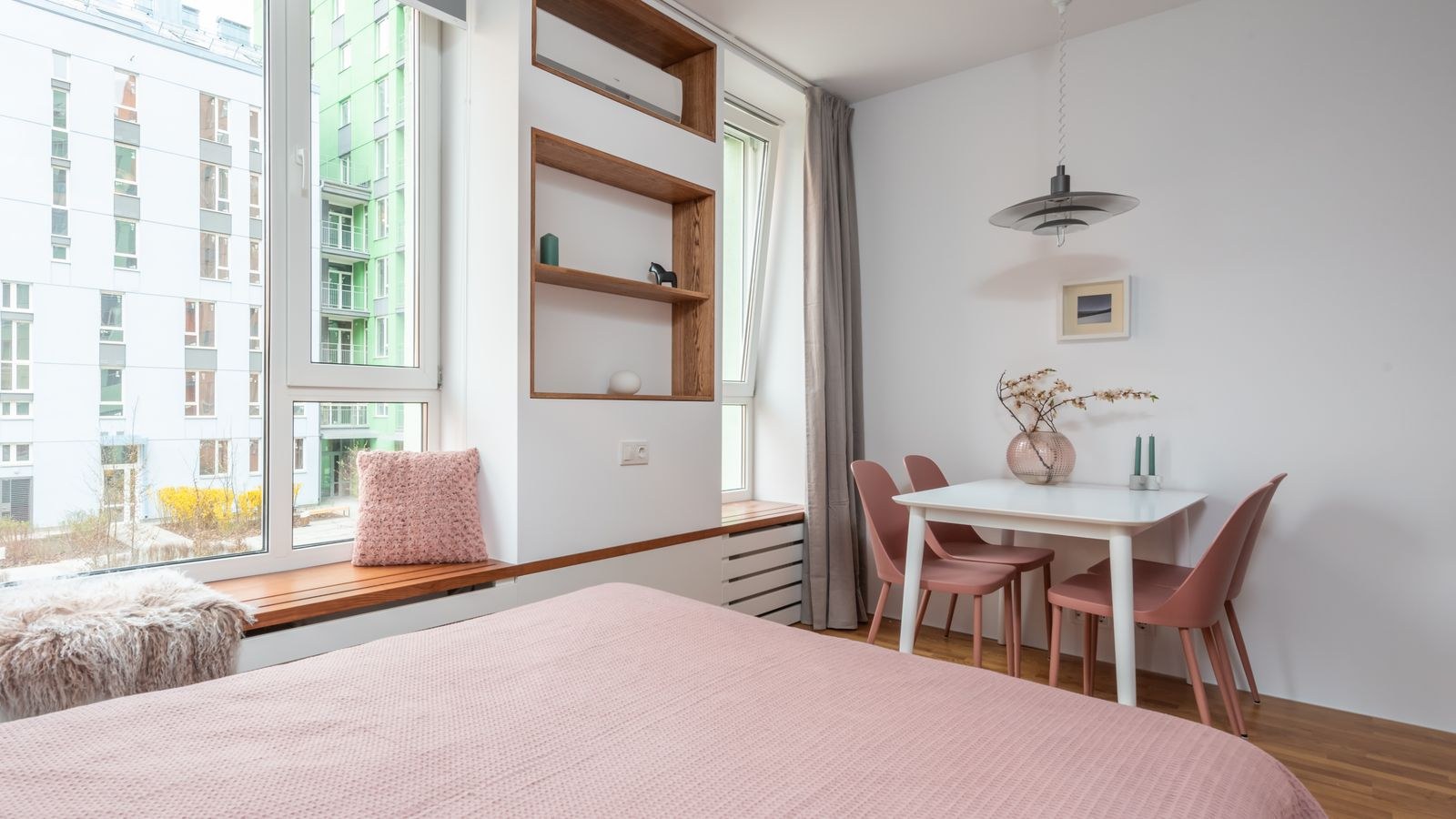 Rental bedroom with soft bedding and layered lamp lighting near a window