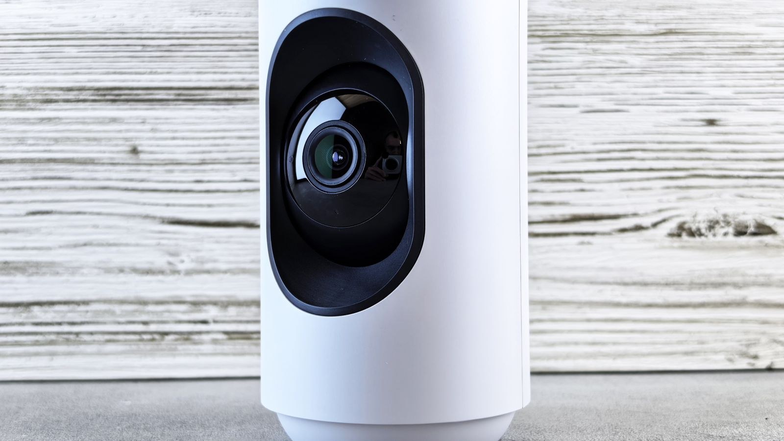 Compact indoor security camera placed on a shelf in a rental home
