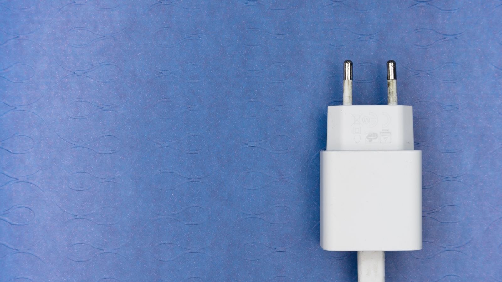 Black plug inserted into a white wall socket during a smart plug factory reset