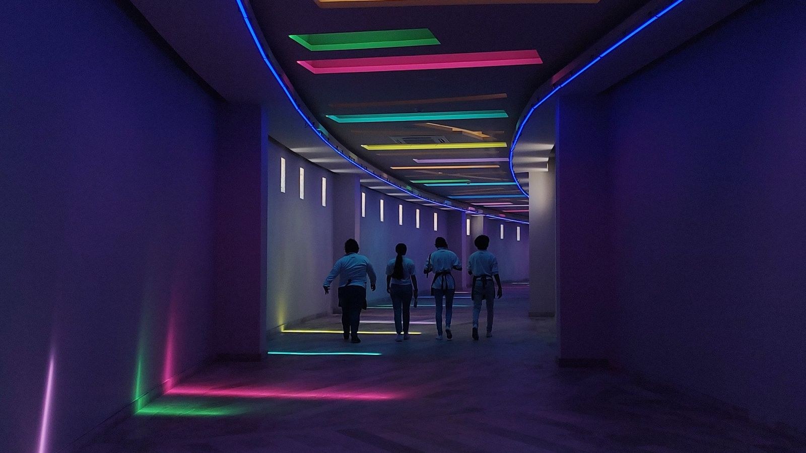 Modern corridor lit by continuous linear LED lighting along the walls