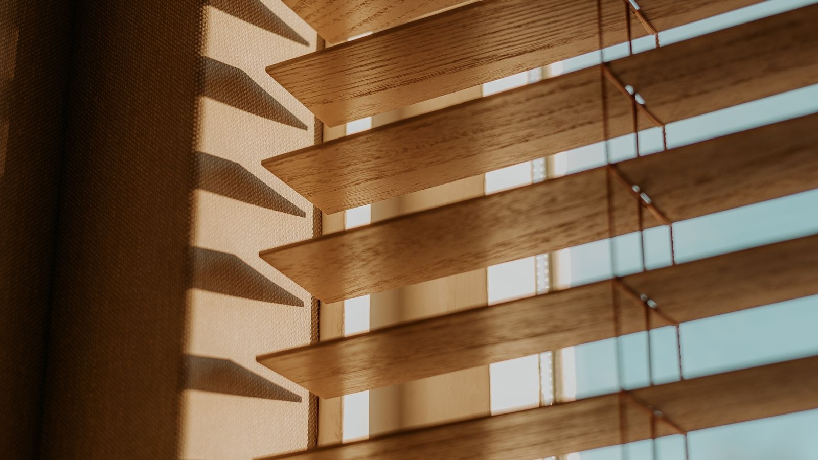 Warm sunlight filtering through wooden blinds in a living room