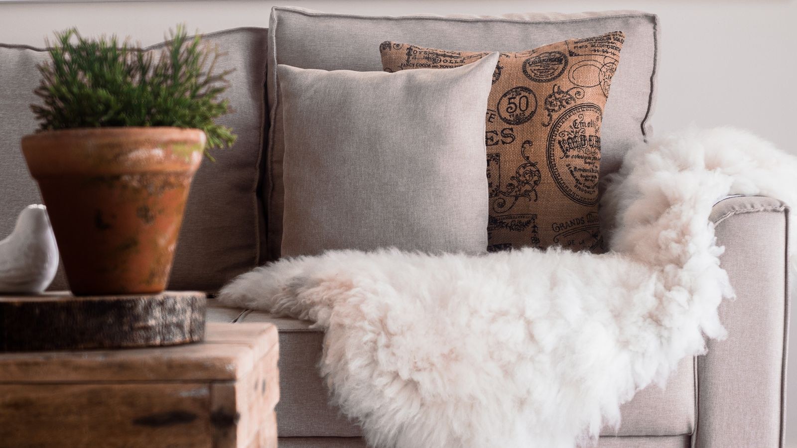 Cozy living room with fur throws layered on a sofa for autumn