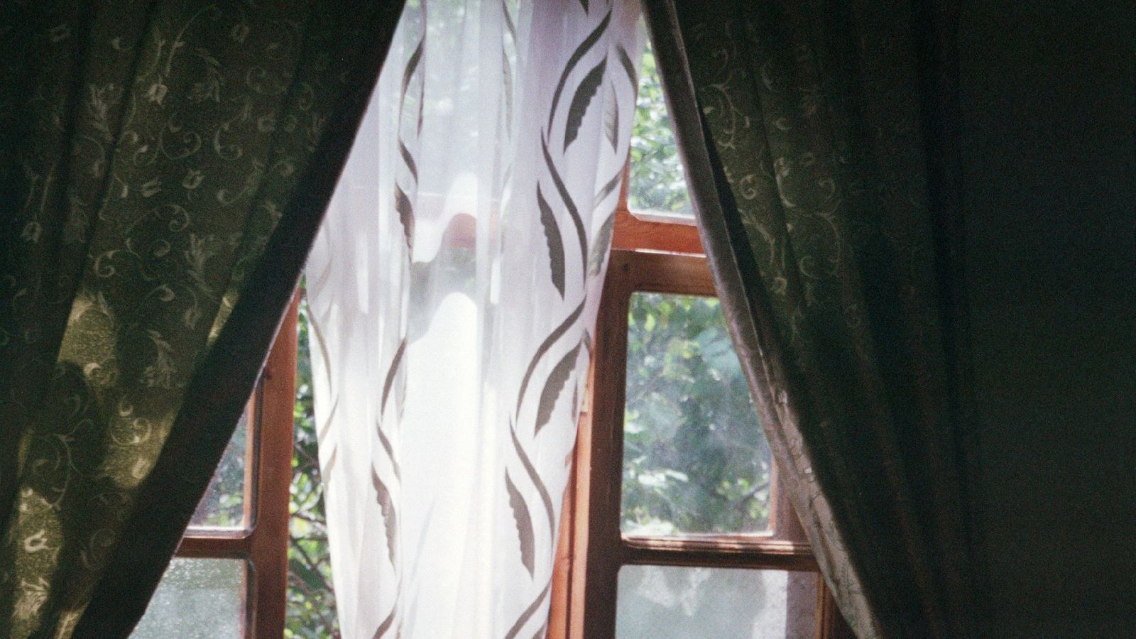 Sunlit room with elegant curtains framing a large window