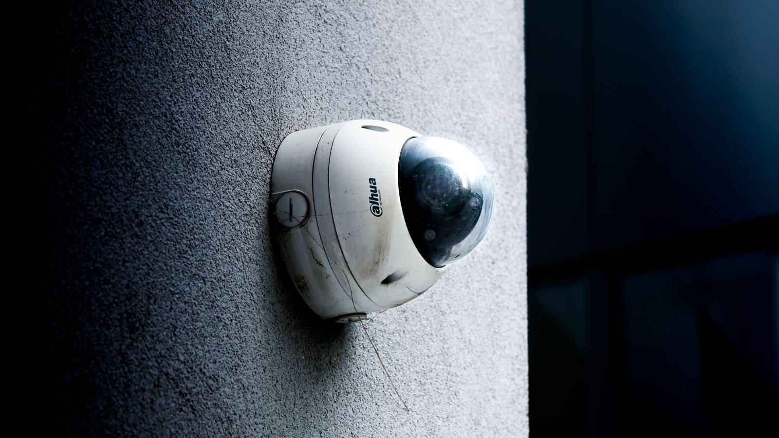 Outdoor security camera on a concrete wall in daylight