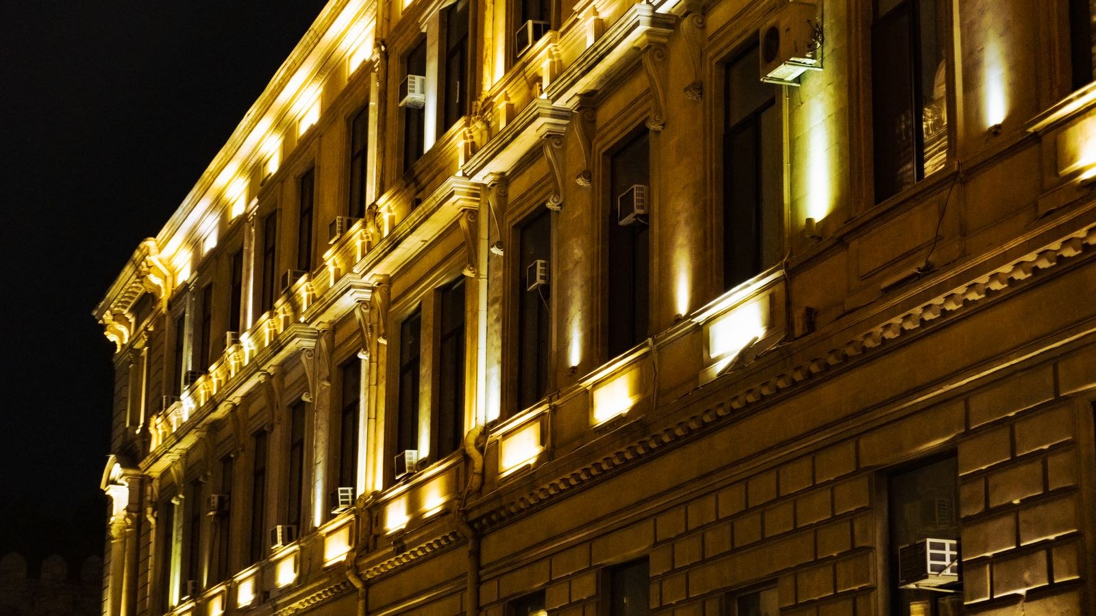 Building facade illuminated by warm exterior security lights at night