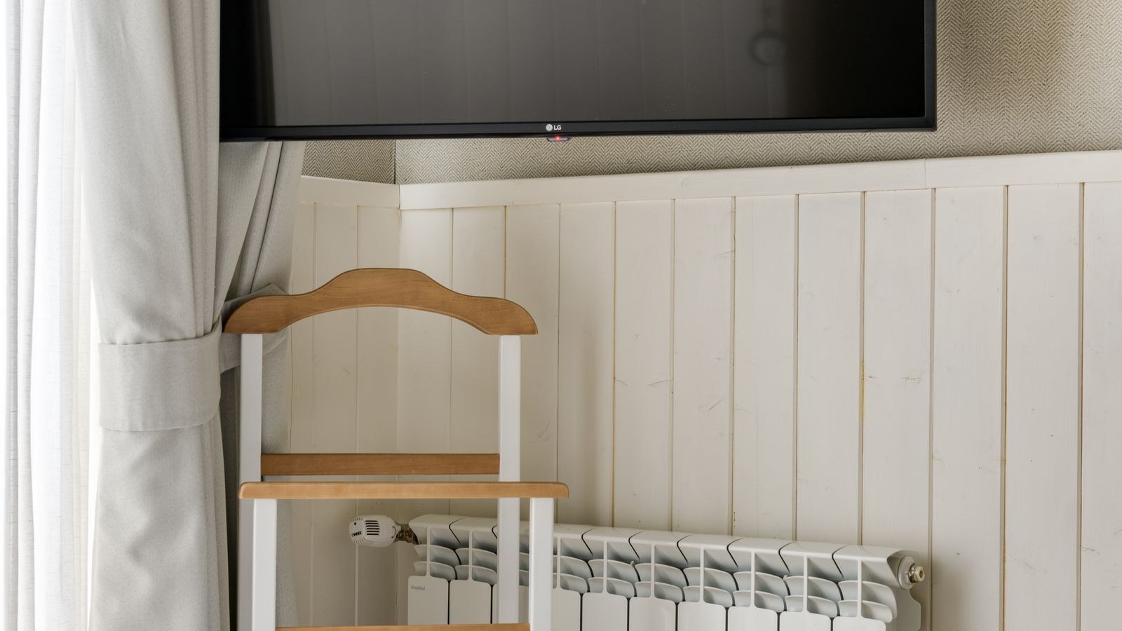 Bedroom television mounted on a wall with soft ambient lighting at night