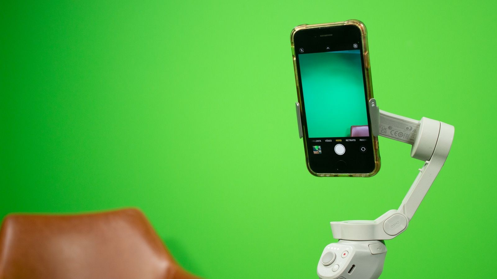 Smartphone on a stabilizer in front of a green screen video production setup