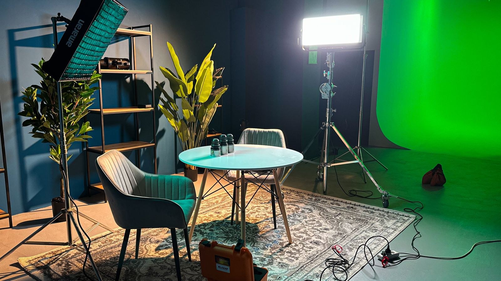 Well-lit indoor studio designed for filming with a green screen backdrop