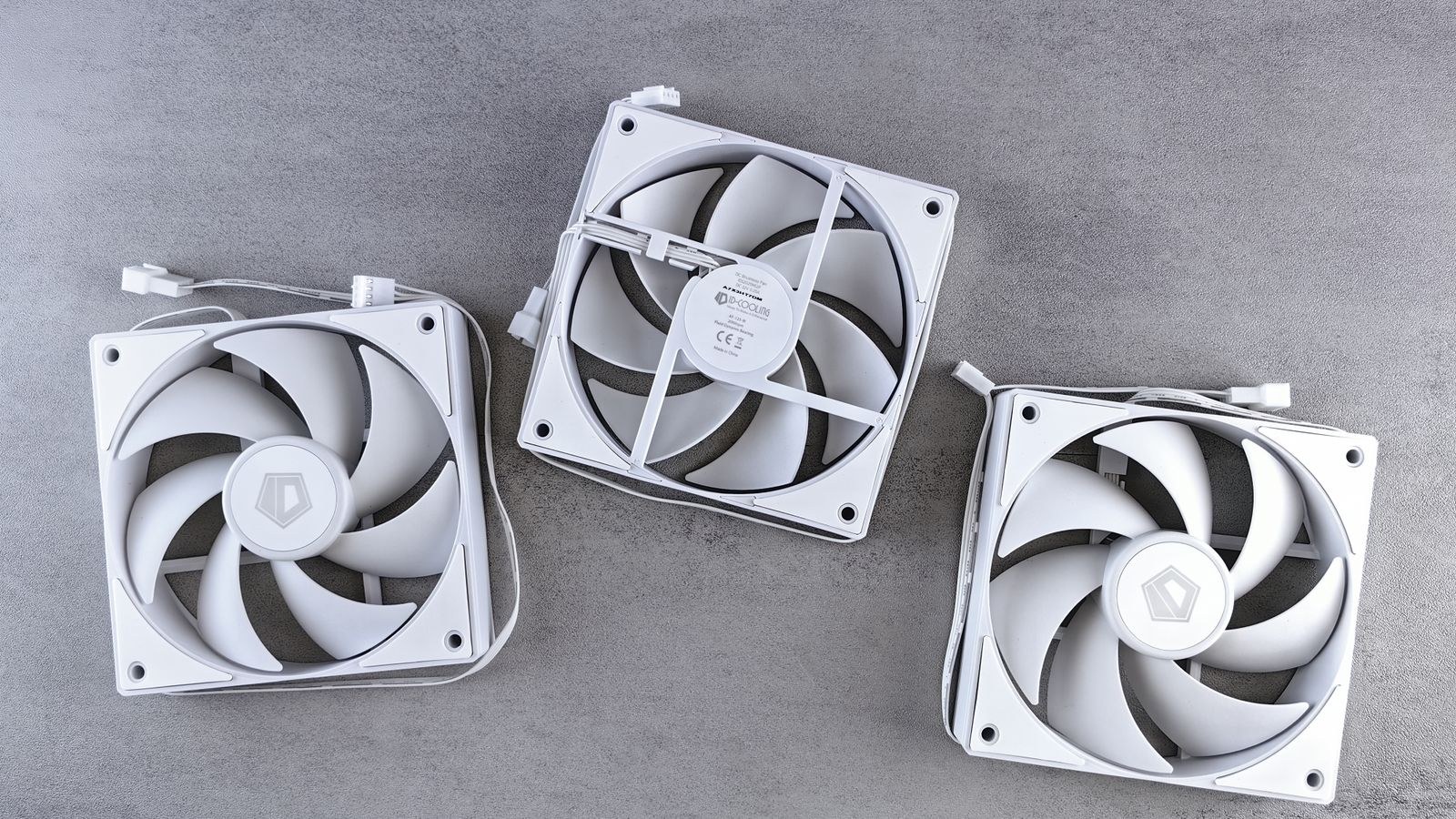 Three white computer case cooling fans on a grey background