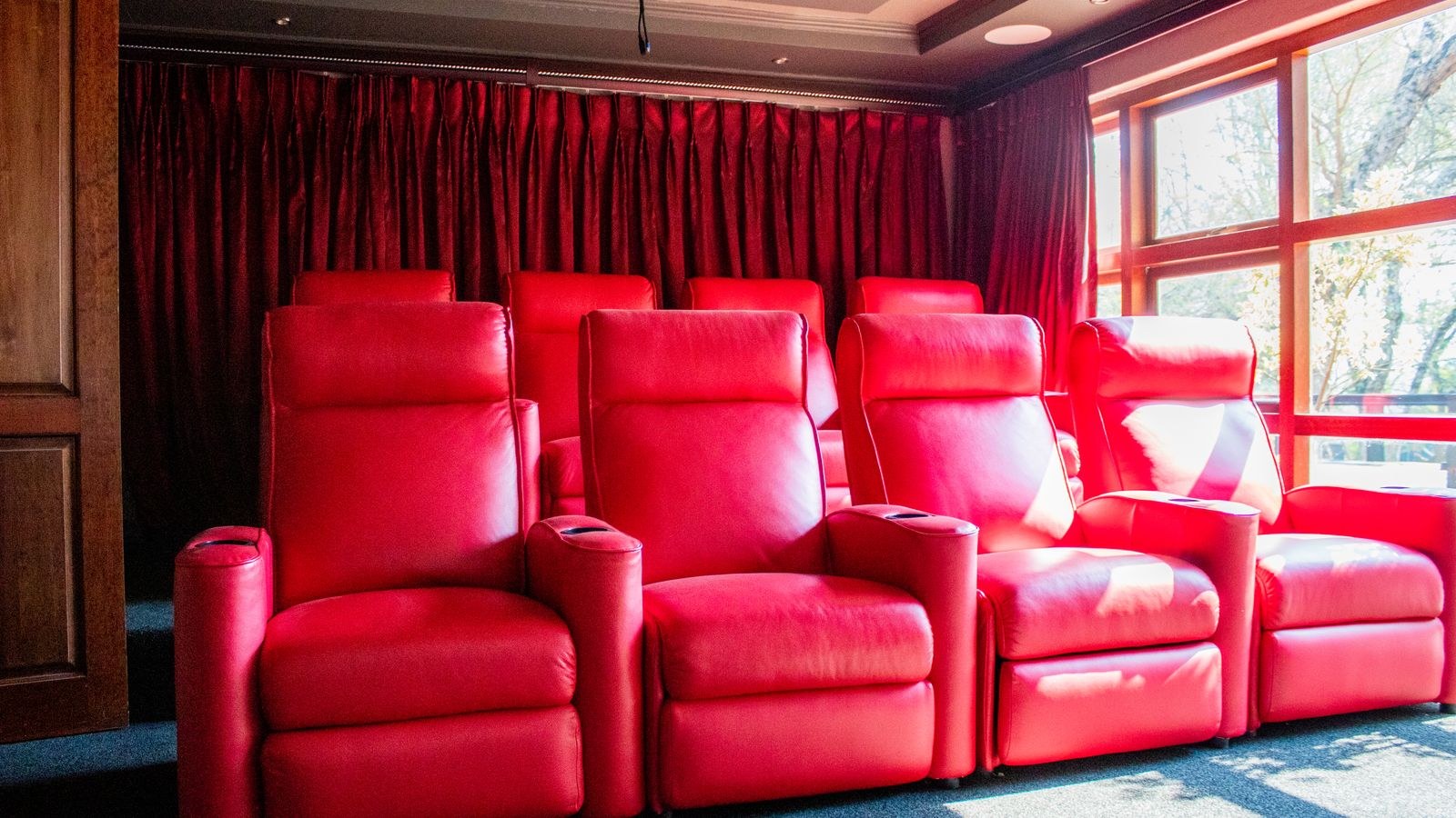 Home theater seating beneath ceiling mounted Dolby Atmos height speakers