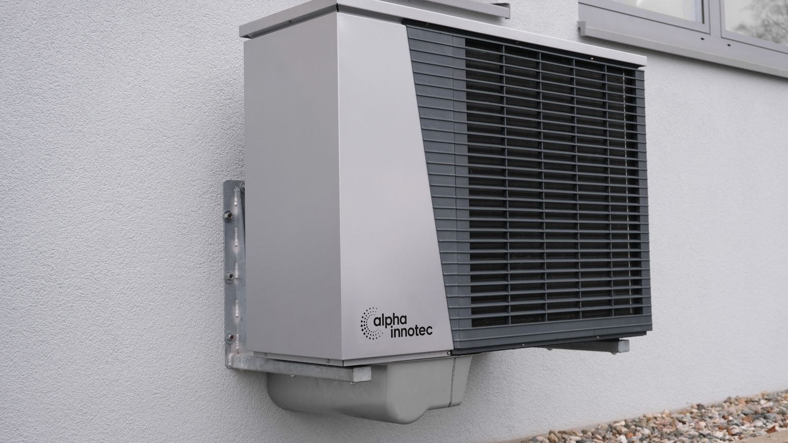 Outdoor air source heat pump unit mounted on a residential building exterior