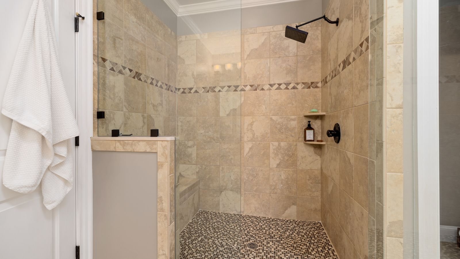 Tiled shower interior with glass door and modern fixtures