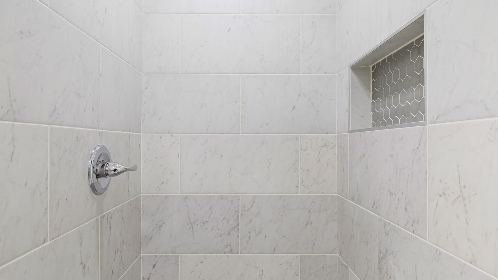Minimalist shower with grey tiled floor and walls