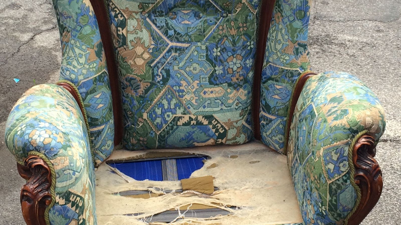 Worn vintage armchair with torn upholstery needing reupholstery