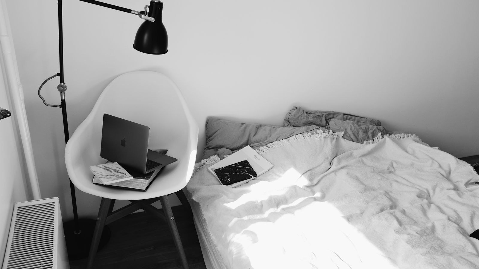 Small bedroom workspace with a laptop and natural light in a compact apartment