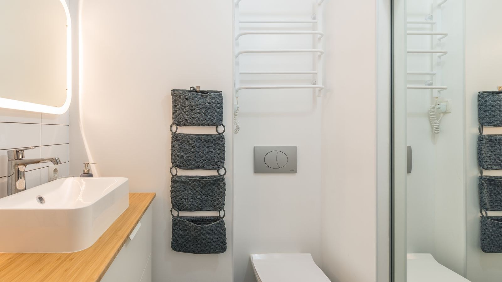 Small bathroom with illuminated mirror and toilet suitable for motion night lighting