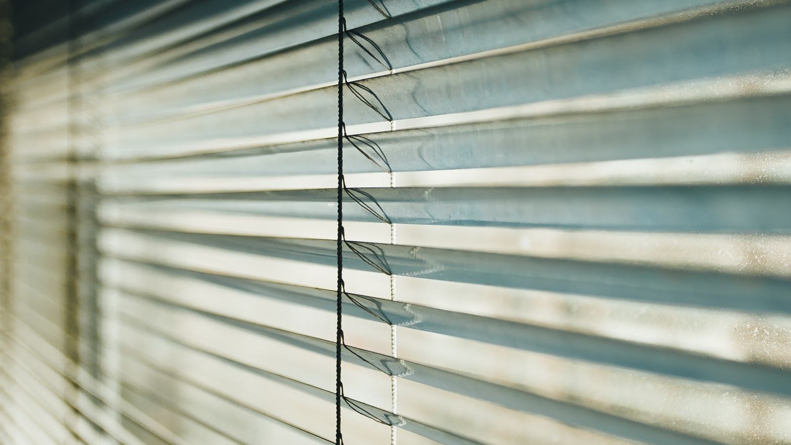 Sunlight filtering through automated window shades in a bright room