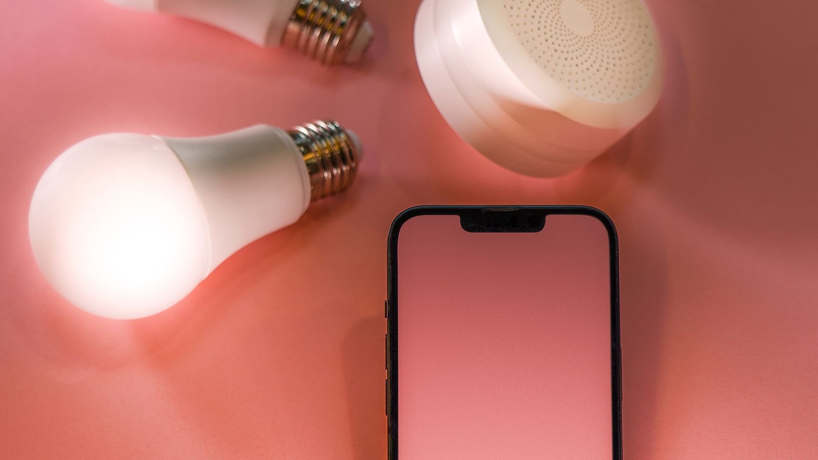 Smart light bulbs arranged around a smartphone controlling home lighting